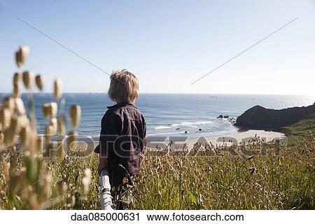 Child looking at tranquil beach view View Large Photo Image Stock Image - Child looking at tranquil beach view. Fotosearch