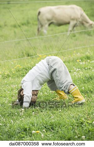 Child playing in grass on farm View Large Photo Image Stock Photo - Child playing in grass on farm. Fotosearch
