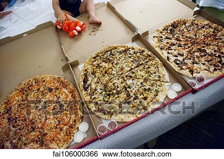 Child sitting near large pizzas in open boxes View Large Photo Image Stock Photograph - Child sitting near large pizzas in open boxes. Fotosearch