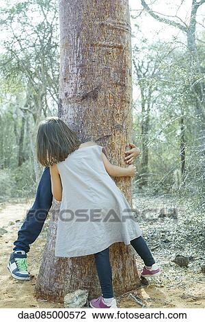 Stock Image - Children playing hide-and-seek in woods. Fotosearch