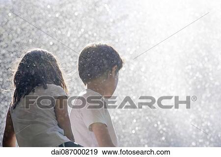 Children surrounded by spray from waterfall View Large Photo Image Stock Photo - Children surrounded by spray from waterfall. Fotosearch