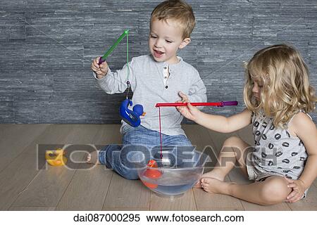 Children using toy fishing rods to catch rubber ducks floating in large bowl View Large Photo Image Stock Photography - Children using toy fishing rods to catch rubber ducks floating in large bowl. Fotosearch