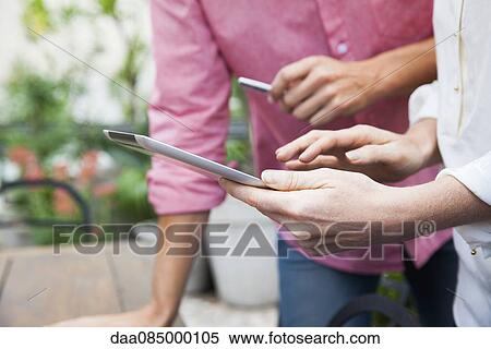 Colleagues using digital tablet View Large Photo Image Stock Photography - Colleagues using digital tablet. Fotosearch