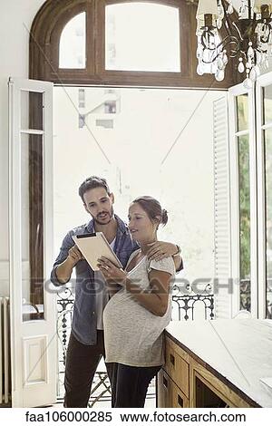 Couple at home looking at digital tablet together View Large Photo Image Stock Photography - Couple at home looking at digital tablet together. Fotosearch