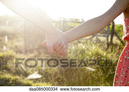 Picture - Couple holding hands, close-up. Fotosearch