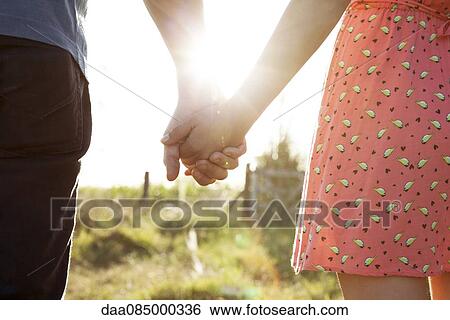 Stock Photograph - Couple holding hands, close-up. Fotosearch