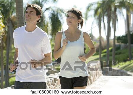 Couple jogging together in park View Large Photo Image Stock Image - Couple jogging together in park. Fotosearch