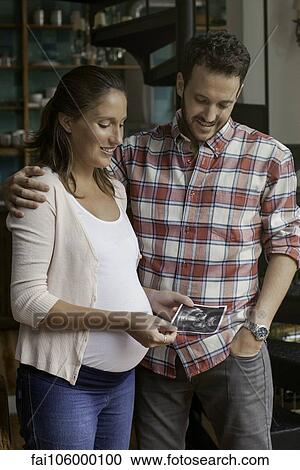 Couple looking at ultrasound photo together View Large Photo Image Stock Image - Couple looking at ultrasound photo together. Fotosearch