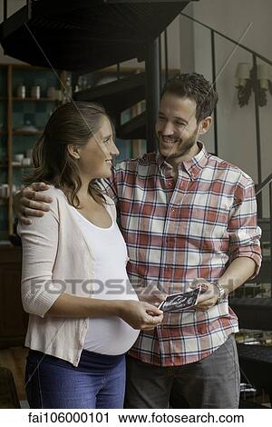 Couple looking at ultrasound photo together View Large Photo Image Stock Image - Couple looking at ultrasound photo together. Fotosearch