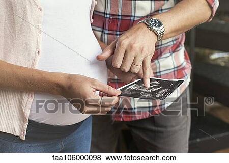 Couple looking at ultrasound photo together View Large Photo Image Stock Photo - Couple looking at ultrasound photo together. Fotosearch