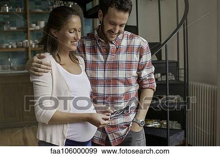 Stock Photo - Couple looking at ultrasound photo together. Fotosearch