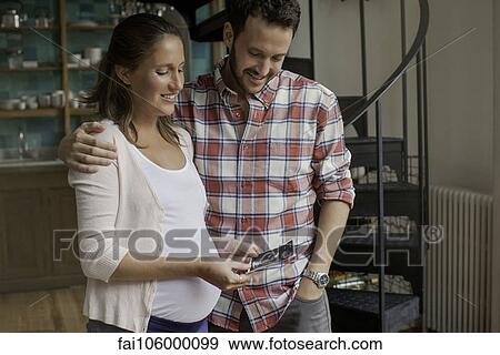 Couple looking at ultrasound photo together View Large Photo Image Stock Photo - Couple looking at ultrasound photo together. Fotosearch