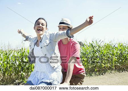 Couple riding bike together, woman with arms outstretched View Large Photo Image Stock Photo - Couple riding bike together, woman with arms outstretched. Fotosearch