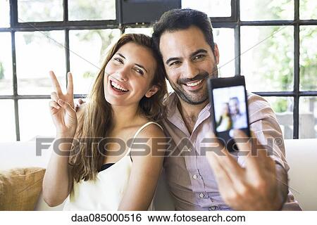 Stock Photograph - Couple taking selfie. Fotosearch