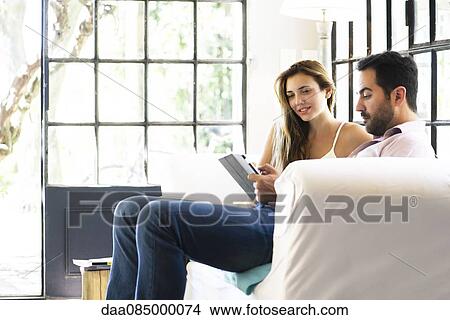 Couple using digital tablet at home View Large Photo Image Picture - Couple using digital tablet at home. Fotosearch