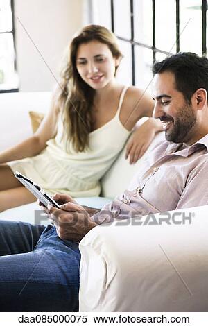 Couple using digital tablet at home View Large Photo Image Stock Photography - Couple using digital tablet at home. Fotosearch