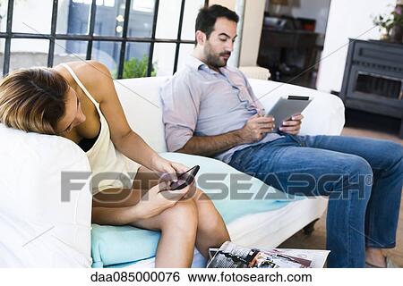 Couple using wireless devices at home View Large Photo Image Stock Photograph - Couple using wireless devices at home. Fotosearch