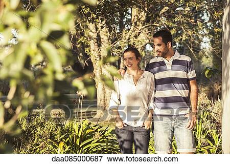 Couple walking through botanical garden looking at view View Large Photo Image Stock Photo - Couple walking through botanical garden looking at view. Fotosearch