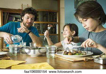 Family eating dinner together View Large Photo Image Picture - Family eating dinner together. Fotosearch
