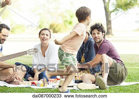Family enjoying picnic in park, boy running around View Large Photo Image Stock Image - Family enjoying picnic in park, boy running around. Fotosearch