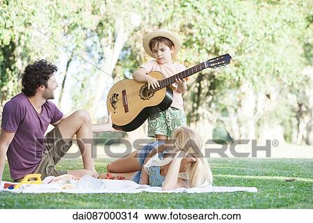 Picture - Family enjoying quality time together picnicking in park. Fotosearch