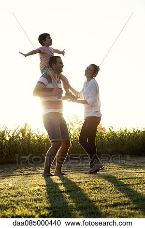 Stock Image - Family with little boy having fun at the park. Fotosearch