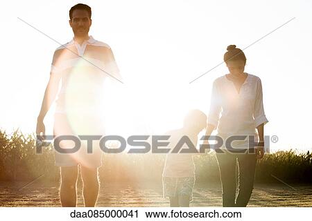 Family with little boy walking together outdoors View Large Photo Image Stock Image - Family with little boy walking together outdoors. Fotosearch