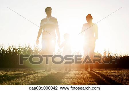 Family with little boy walking together outdoors View Large Photo Image Stock Image - Family with little boy walking together outdoors. Fotosearch