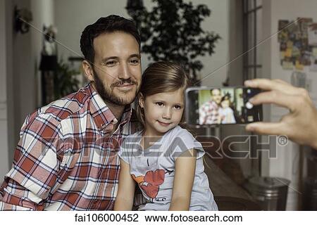 Stock Image - Father and daughter posing for photo. Fotosearch