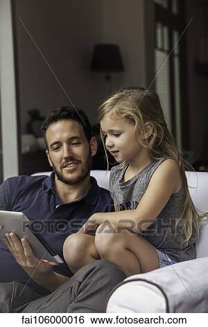 Father and daughter using digital tablet together View Large Photo Image Stock Photograph - Father and daughter using digital tablet together. Fotosearch