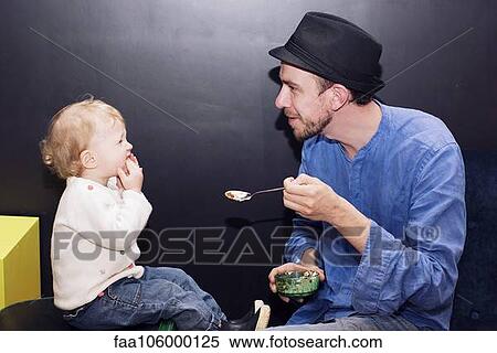 Stock Photography - Father feeding toddler. Fotosearch
