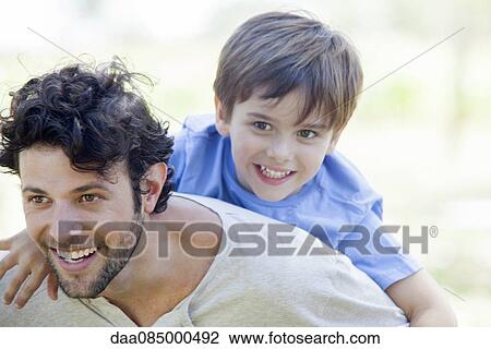 Father giving little boy piggyback ride View Large Photo Image Stock Image - Father giving little boy piggyback ride. Fotosearch