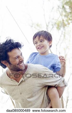Stock Photo - Father giving little boy piggyback ride. Fotosearch