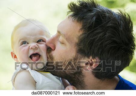 Father kissing baby's cheek View Large Photo Image Stock Image - Father kissing baby's cheek. Fotosearch