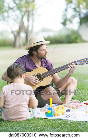 Father playing acoustic guitar next to son View Large Photo Image Stock Image - Father playing acoustic guitar next to son. Fotosearch