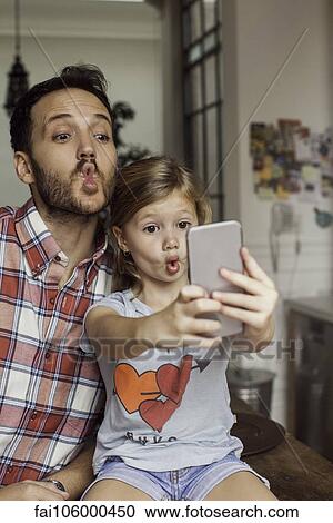 Stock Image - Father posing for selfie with daughter. Fotosearch