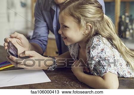 Father showing daughter video streaming on smartphone View Large Photo Image Stock Image - Father showing daughter video streaming on smartphone. Fotosearch