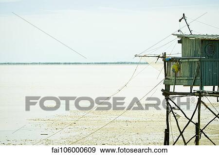 Stock Photo - Fishing hut on stilts near water's edge. Fotosearch