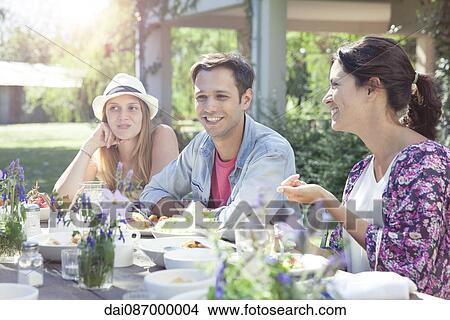 Friends chatting while enjoying healthy meal together View Large Photo Image Picture - Friends chatting while enjoying healthy meal together. Fotosearch