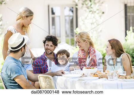 Friends enjoying meal and talking outdoors View Large Photo Image Stock Photo - Friends enjoying meal and talking outdoors. Fotosearch