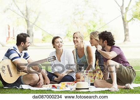 Friends enjoying picnic in park View Large Photo Image Picture - Friends enjoying picnic in park. Fotosearch