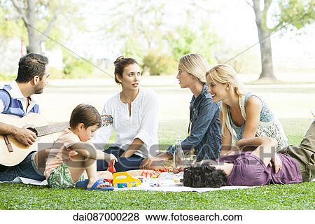 Friends enjoying picnic in park View Large Photo Image Stock Photo - Friends enjoying picnic in park. Fotosearch