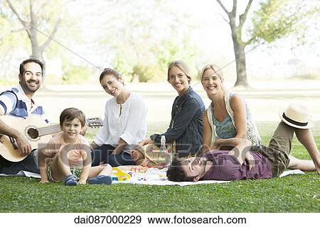 Stock Photo - Friends enjoying picnic in park. Fotosearch