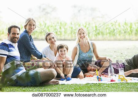 Friends enjoying picnic in park View Large Photo Image Stock Photo - Friends enjoying picnic in park. Fotosearch