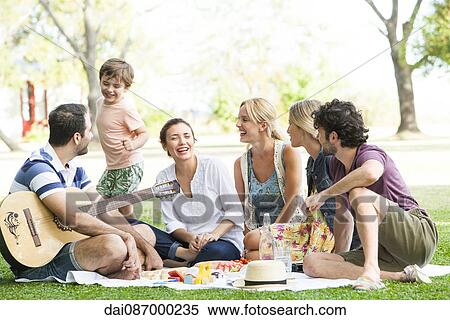 Stock Photography - Friends enjoying picnic in park. Fotosearch