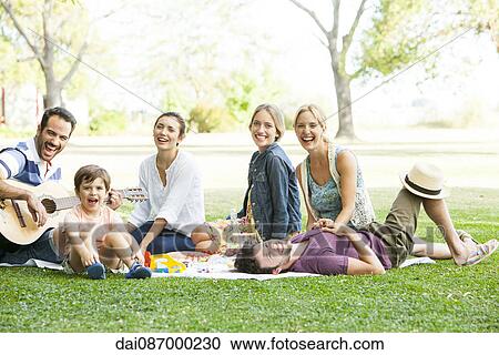Friends relaxing together in the park View Large Photo Image Stock Image - Friends relaxing together in the park. Fotosearch