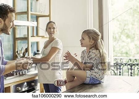 Girl chatting with parents preparing family meal in kitchen View Large Photo Image Stock Image - Girl chatting with parents preparing family meal in kitchen. Fotosearch