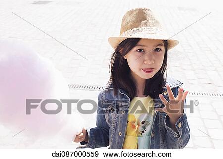 Girl eating cotton candy, portrait View Large Photo Image Stock Photo - Girl eating cotton candy, portrait. Fotosearch