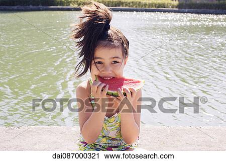 Girl eating watermelon outdoors View Large Photo Image Stock Image - Girl eating watermelon outdoors. Fotosearch