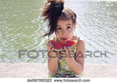 Girl eating watermelon outdoors View Large Photo Image Stock Image - Girl eating watermelon outdoors. Fotosearch